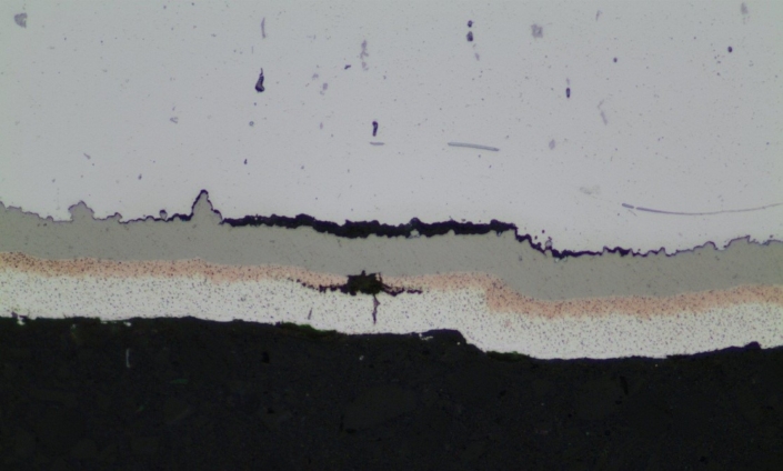 mauvaise adhérence d'un revêtement tri-couches (nickel au phosphore, cuivre et couche final argent, substrat aluminium) visible sur coupe micrographique